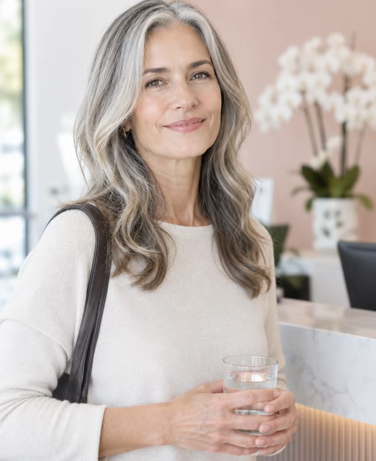 A client at the Lumen reception after a treatment, holding a glass of water.