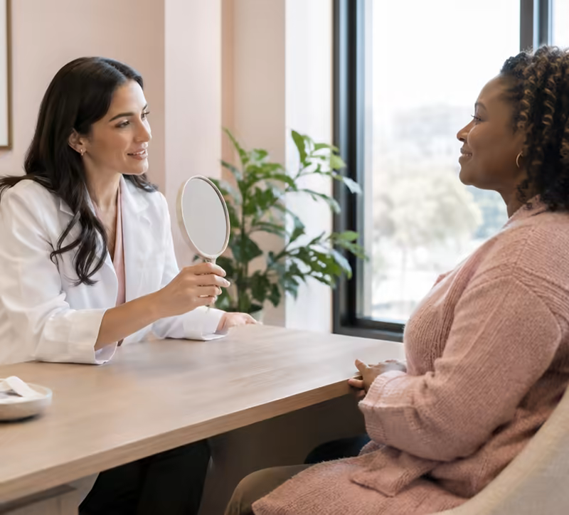 A doctor consulting with a client across a desk.